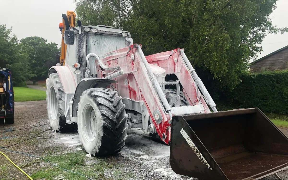 Agricultural tractor covered in cleaning foam